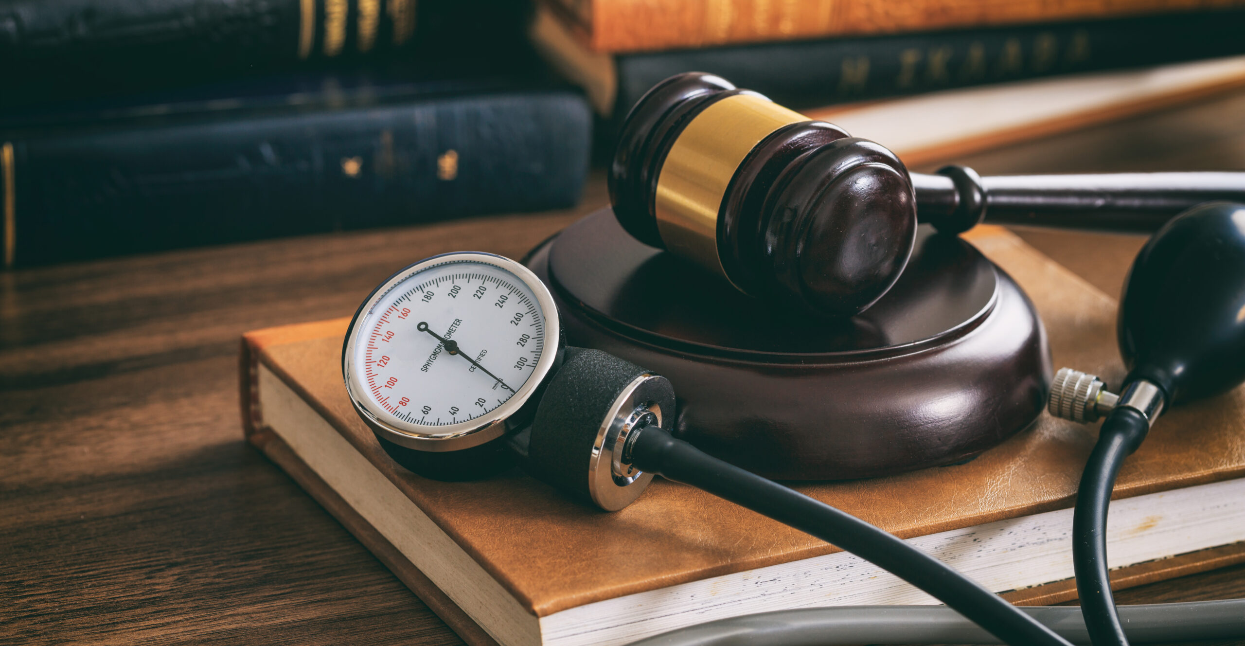 Judge gavel and a blood pressure gauge on a wooden desk